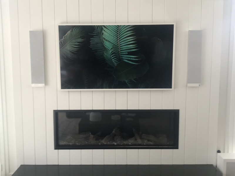 A TV securely mounted above a fireplace